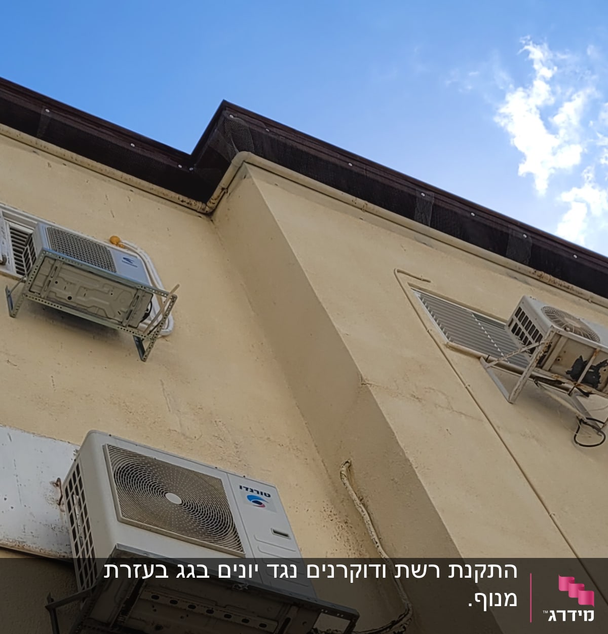 מזגנים מותקנים על קיר בניין עם הגנה נגד יונים